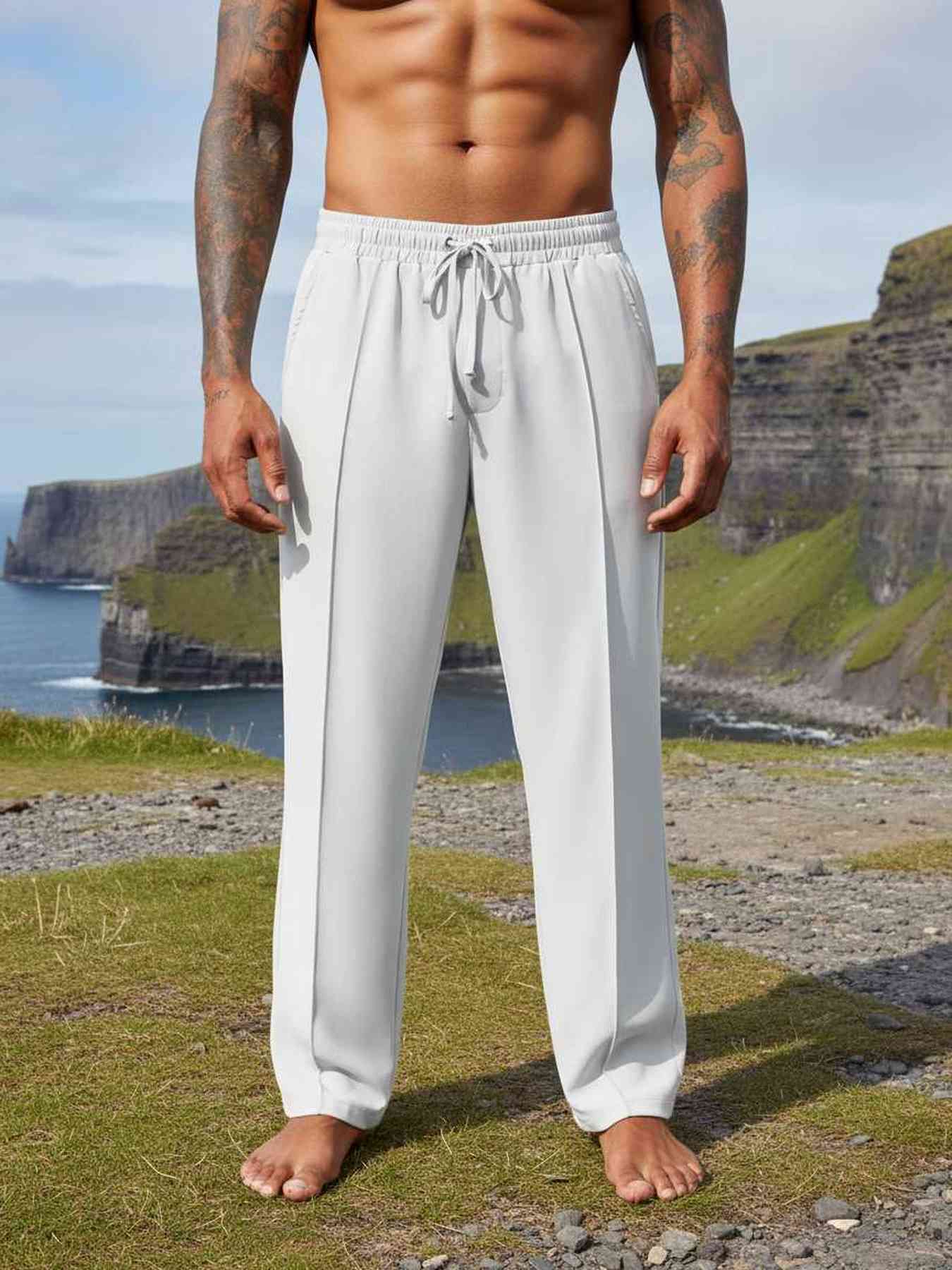 Men's light gray drawstring joggers on grassy cliffside with ocean view