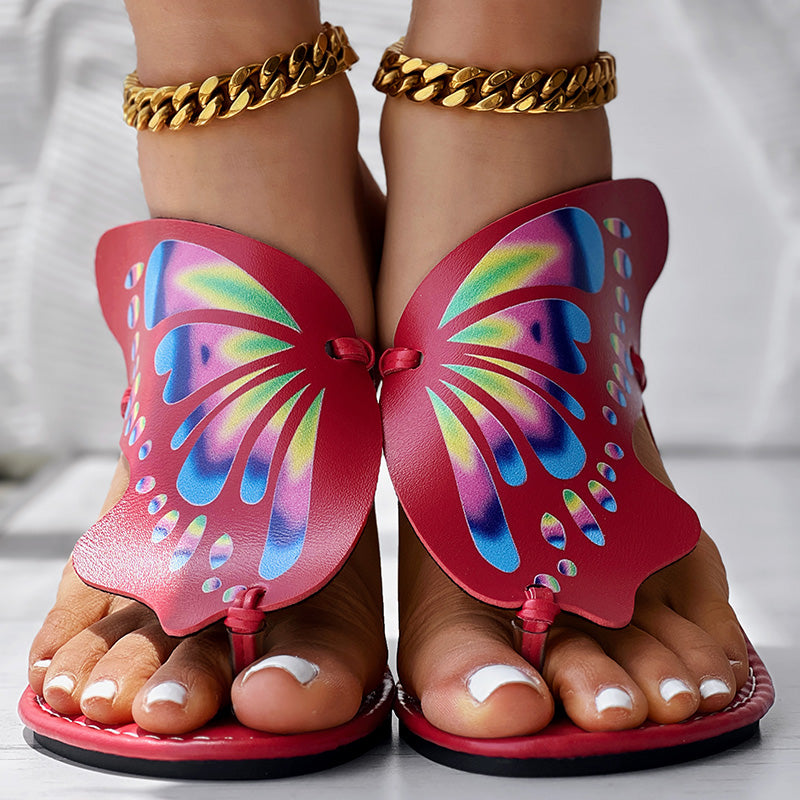 Red butterfly wing sandals with colorful gradient wings, gold chain anklets, white pedicure